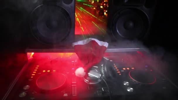 クリスマス ツリー大晦日と暗いナイトクラブ背景にヘッドフォンで dj ミキサー。Dj テーブルの新しい年の要素のビューを閉じます。休日党概念。空の空間 - 映像、動画