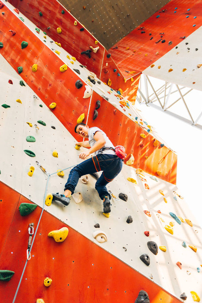 Giovane uomo si arrampica su una parete di roccia all'aperto - Foto, immagini