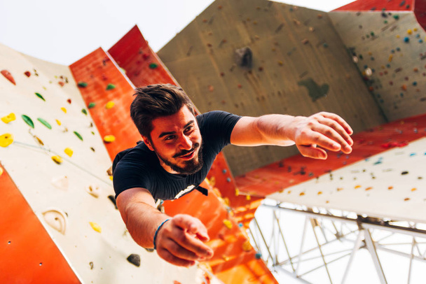 Giovane uomo che pratica il bouldering in palestra di arrampicata all'aperto
 - Foto, immagini