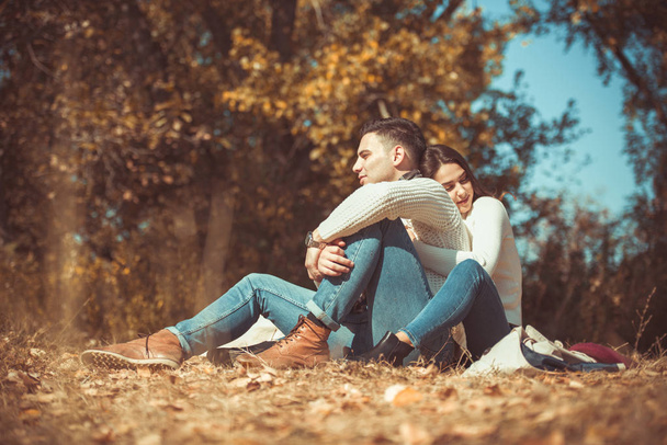 Sweet couple is outdoors, they are looking very happy while  hugging in the autumn park - Фото, зображення