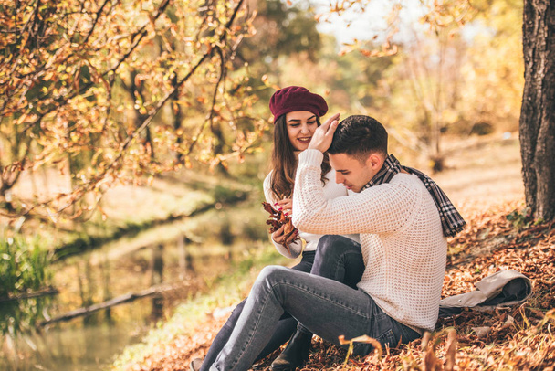 公園の秋の日を愛するカップルの支出, 草の上に座って、自然を楽しむ - 写真・画像