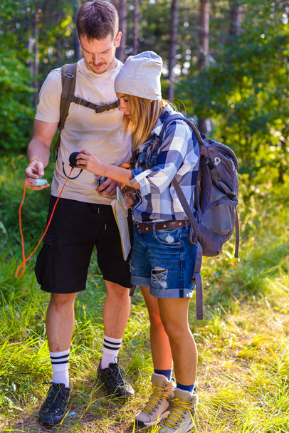 junges Paar, das die Musik auf externen Lautsprechern spielt, während es im Wald spaziert. Wanderkonzept in den Bergen im Sommer - Foto, Bild