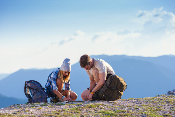 A couple enjoying the peak of the mountain, cliff at sunset. Success, winners. - Photo, Image