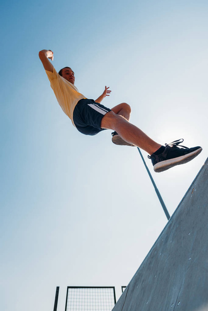 Parkour man training hard while run through obstacles in skatepark - Photo, image