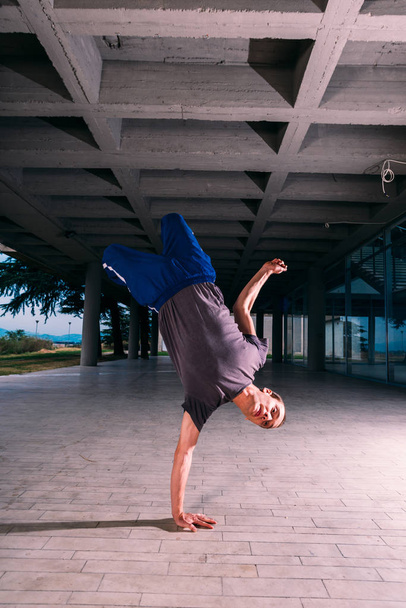 Fitness guy make handstand in city center - Photo, Image
