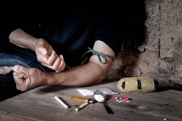 Niño drogadicto inyectándose heroína en el brazo
 - Foto, Imagen