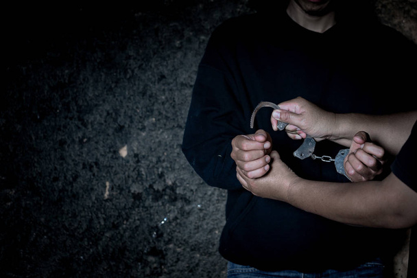 Recht en politie concept. Politie arrestatie drug mensenhandelaar met handboeien. - Foto, afbeelding