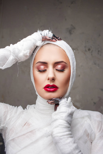 Glamorous mummy. Portrait of a young beautiful woman in bandages all over her body - 写真・画像