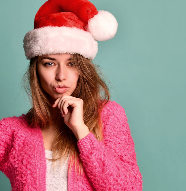 Beautiful female model wear xmas santa hat happy smiling kissing in pink blouse on blue mint - Foto, Imagen