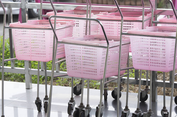 Małe wózki sklepowe różowy kolor w sklepie detalicznym dom towarowy. - Zdjęcie, obraz