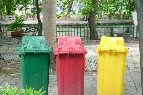 Διαφορετικά χρώματα τρεις κάδους σκουπιδιών σε δημόσιο χώρο, προστασία του περιβάλλοντος - Φωτογραφία, εικόνα