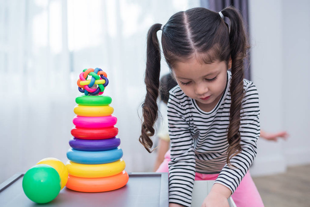 kleine Mädchen, die zu Hause kleine Spielzeugkörbe spielen. Bildung und Glück Lebensstil Konzept. Lustiges Lernen und kindliche Entwicklung. Lächeln Gesichter - Foto, Bild