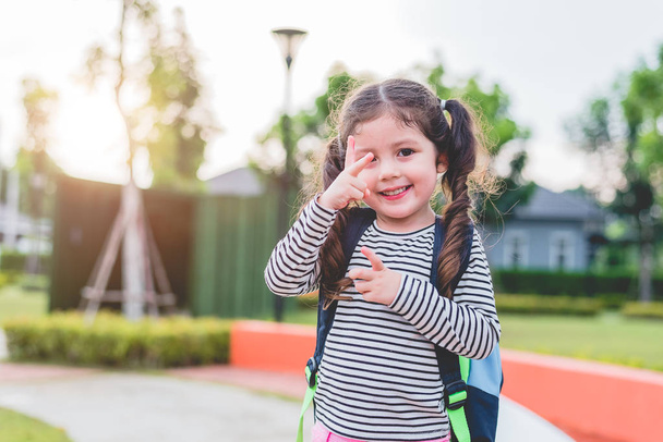 glückliches kleines Mädchen genießt es, zur Schule zu gehen. Zurück zum Schul- und Bildungskonzept. Thema glückliches Leben und Familienleben. - Foto, Bild