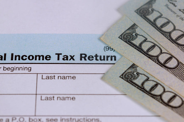 Geschäftskonzept Steuern zahlen usa Steuerformular 1040 mit 100-Dollar-Scheinen. - Foto, Bild