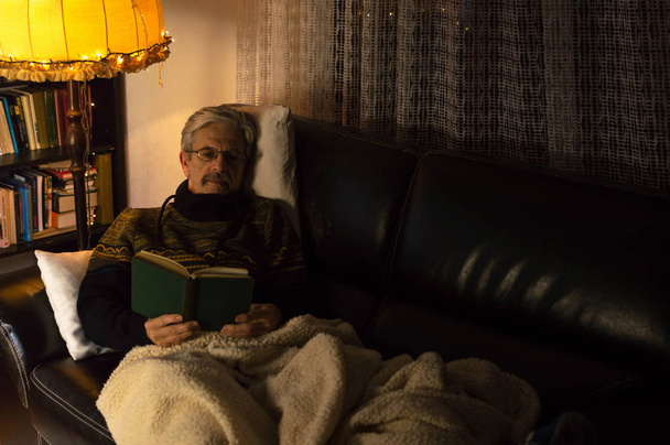 ソファで本を読む老人 - 写真・画像