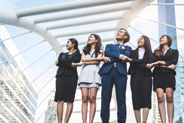 Портрет успішної групи бізнесменів, які розглядають небо як майбутнє. Щасливі бізнесмени і ділові жінки в команді задоволення жест. Успішна група людей, які посміхаються на фоні міста
 - Фото, зображення