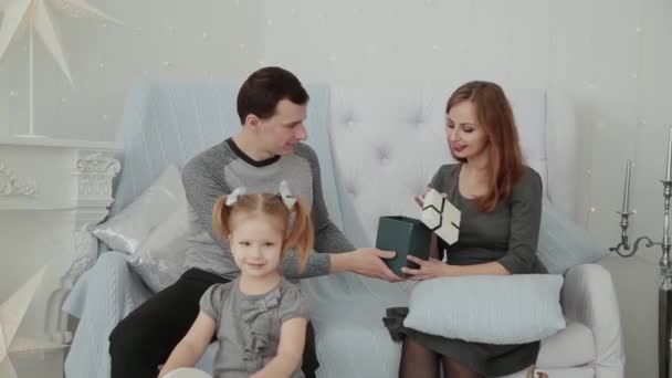 A family of three sitting on the couch and talking on New Years Eve, Christmas 2019. - Imágenes, Vídeo