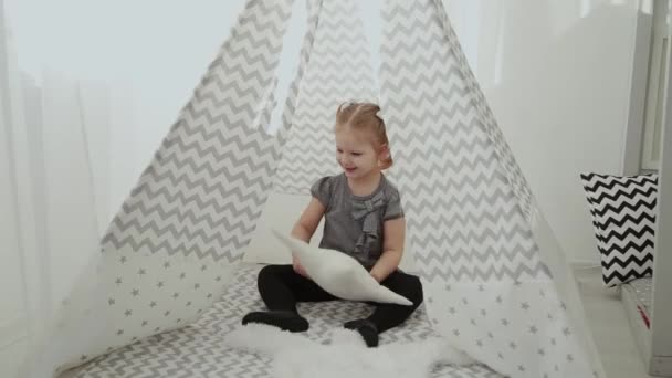 Very beautiful and little girl playing in a tepee. - Filmati, video