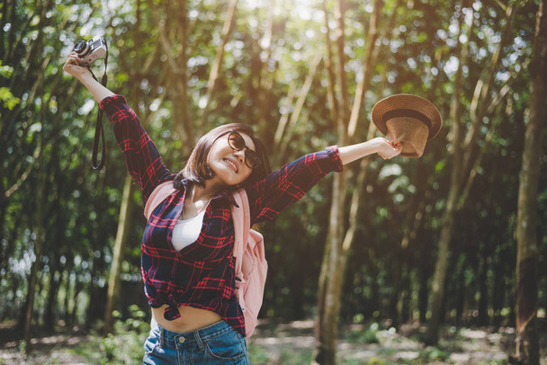ハピネスアジアの旅行者の女性は、腕を広げ、新鮮な空気を楽しむために森の中で女性。リラックスした時間とアドベンチャーのコンセプト。休暇と休日の概念。森と田舎の背景のテーマ. - 写真・画像