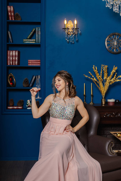 Very beautiful woman drinking champagne in new year decor. - Foto, afbeelding
