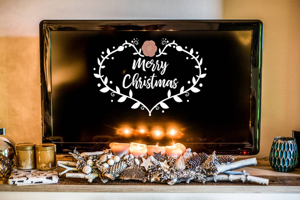 four burning advent candles, beautiful decorated setup light TV in Background textspace saying merry christmas - Valokuva, kuva