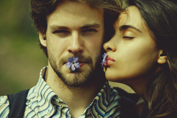 Petite amie et petit ami avec des fleurs bleues dans la bouche
 - Photo, image