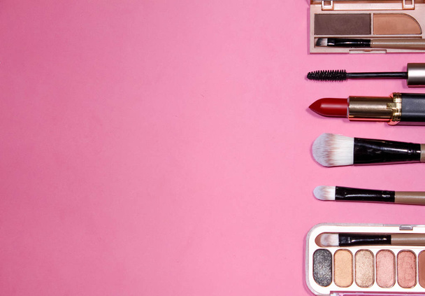flat lay the tools to create makeup on pink background - Foto, afbeelding