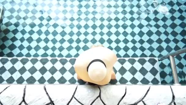 Woman in bikini wearing straw hat in the swimming pool - Footage, Video