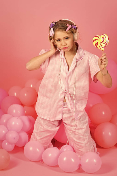 8 or 9 years old child girl eating big multicolor spiral lollipop - Фото, зображення