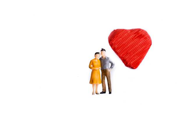 Couple debout devant une forme de coeur sur un fond blanc
 - Photo, image