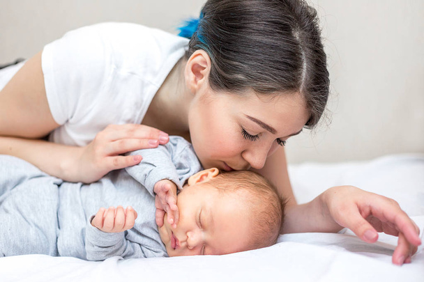 young happy mother is kissing her newborn son - Photo, image