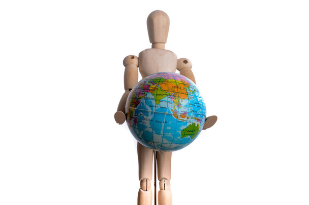 Wooden man holding a globe on a white background - Photo, Image
