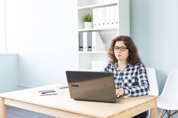 Concepto de tecnología, negocios y personas: mujer seria con gafas que trabaja en la computadora en la oficina
 - Foto, Imagen
