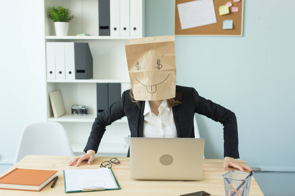 Business, emoties en geld-concept - office gekke vrouw een pakket met geschilderde grappig gezicht op haar hoofd zetten. Dollarteken in haar ogen - Foto, afbeelding