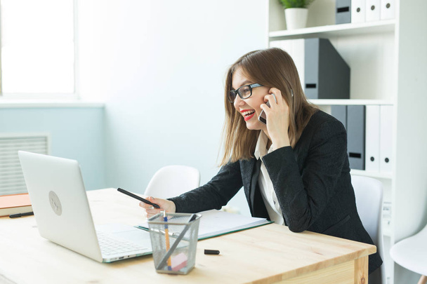 Koncepcja biznesu, nieruchomości i osób - atrakcyjna kobieta w biurze rozmowa na telefon i zrobić notatki - Zdjęcie, obraz