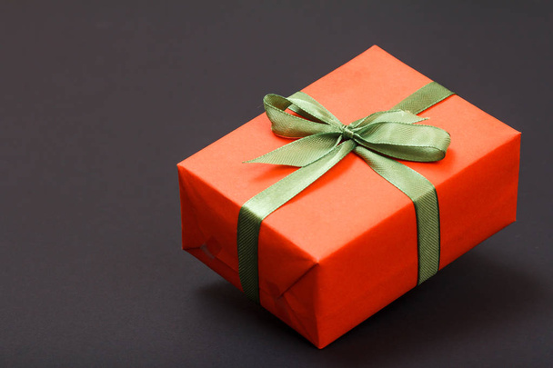 Geschenkbox mit grünem Band auf schwarzem Hintergrund gebunden. Festtagskonzept. - Foto, Bild