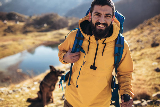 Ταξιδιώτης άνδρα με σακίδιο ορειβασίας. Ταξίδια Lifestyle έννοια στη λίμνη και τα βουνά στο φόντο καλοκαιρινές διακοπές εκστρατεία εξωτερική - Φωτογραφία, εικόνα