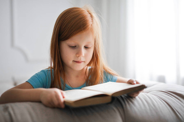 Young little girl reading a book - Foto, imagen