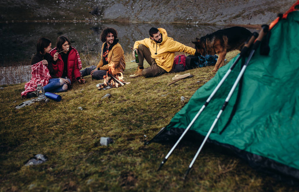 Group of young people around camp fire. - Fotografie, Obrázek