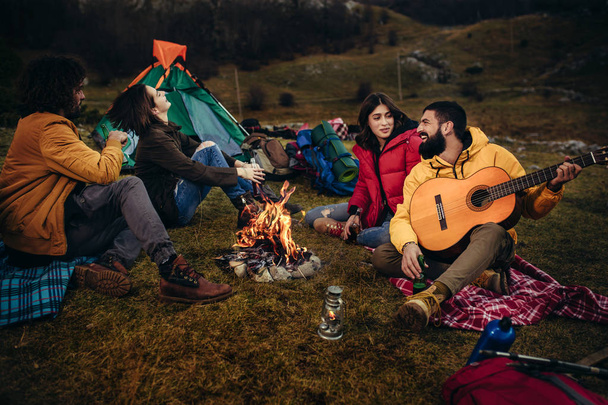 Group of young people around camp fire. - Photo, Image