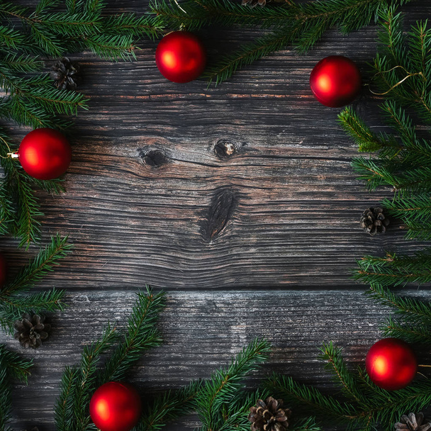 Christmas background with fir branches, red balls and pine cones on wooden. Traditional winter decor for the new year - Fotoğraf, Görsel