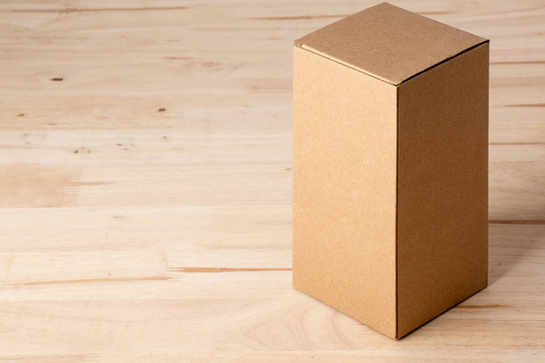lege label kartonnen doos op houten tafel - Foto, afbeelding