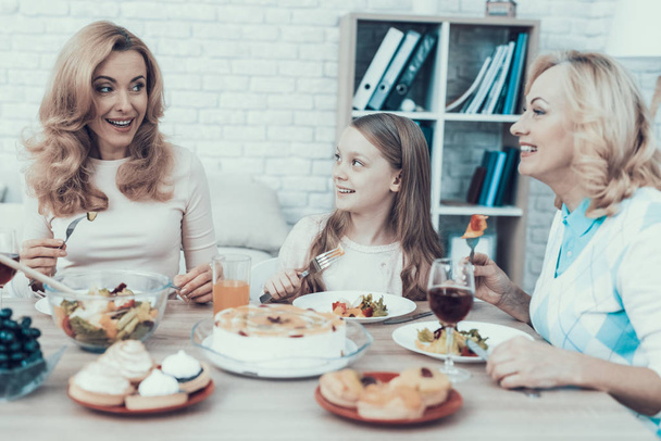 Happy Sitting Family Celebrating Birthday at Home. Cake on Table. Happy Family. Mother with Daughter. Smiling Women. Smiling Grandmother. Celebration Concept. Glass of Wine. Fruits on Plate. - Foto, Imagem