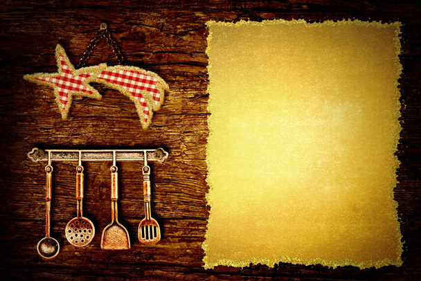 Kerst diner menuachtergrond. Ster doek tafellaken en oude keukengerei opknoping op een rustieke houten muur met lege Perkamentpapier - Foto, afbeelding