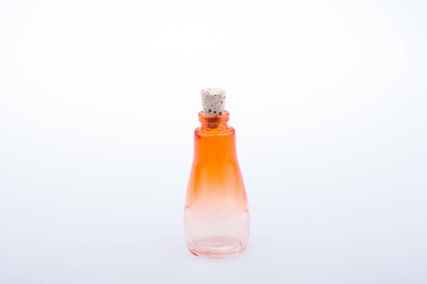 Ребенок держит маленькую красочную пустую стеклянную бутылку на белом фоне
 - Фото, изображение