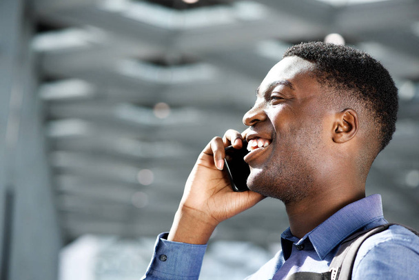 Profil portrait de heureux jeune homme afro-américain parlant sur téléphone portable
 - Photo, image