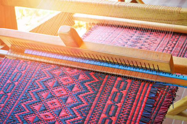 traditionele weven loom voor tapijten stof / weeft kleding produceert hand in thailand - weven kleurrijke mat - Foto, afbeelding