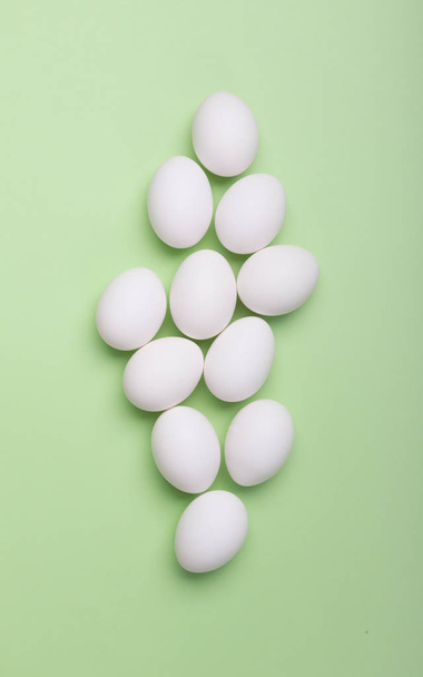 White eggs on the green background. Top view, concept - Foto, Imagen