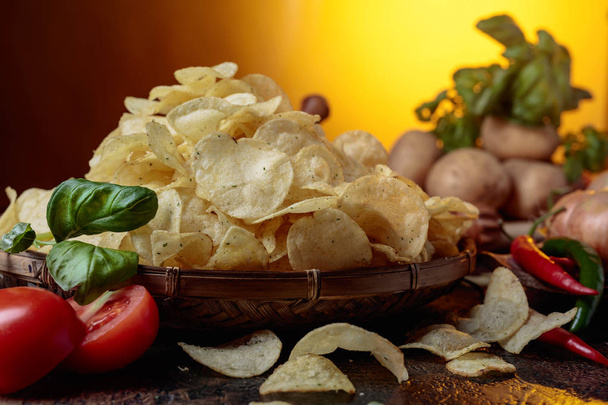 Kartoffelchips mit Gemüse und Gewürzen auf dem Küchentisch. - Foto, Bild