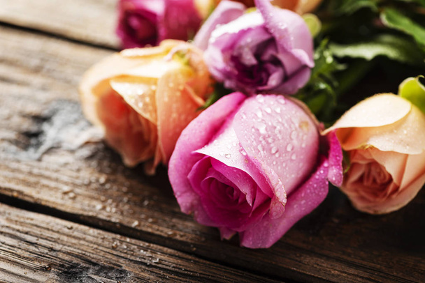 Mix of pink roses on wooden table - 写真・画像